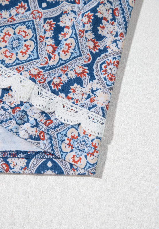 Bohemian print blouse in dusty blue with white lace trim and bell sleeves.