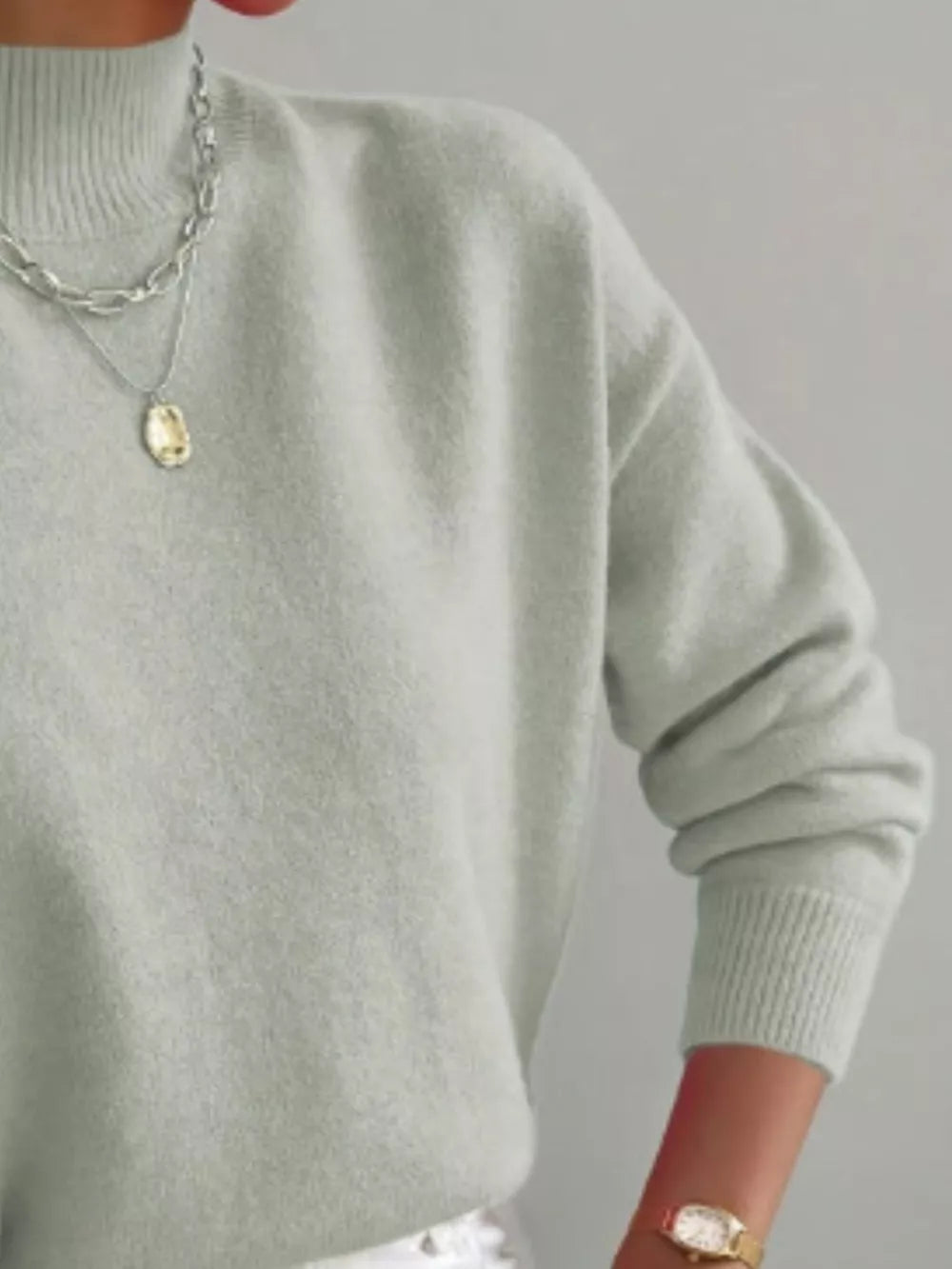Light green mock neck knit sweater with dropped shoulders and ribbed cuffs.