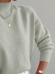 Light green mock neck knit sweater with dropped shoulders and ribbed cuffs.