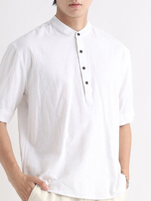Men's white short sleeve button-down blouse with band collar and black buttons.