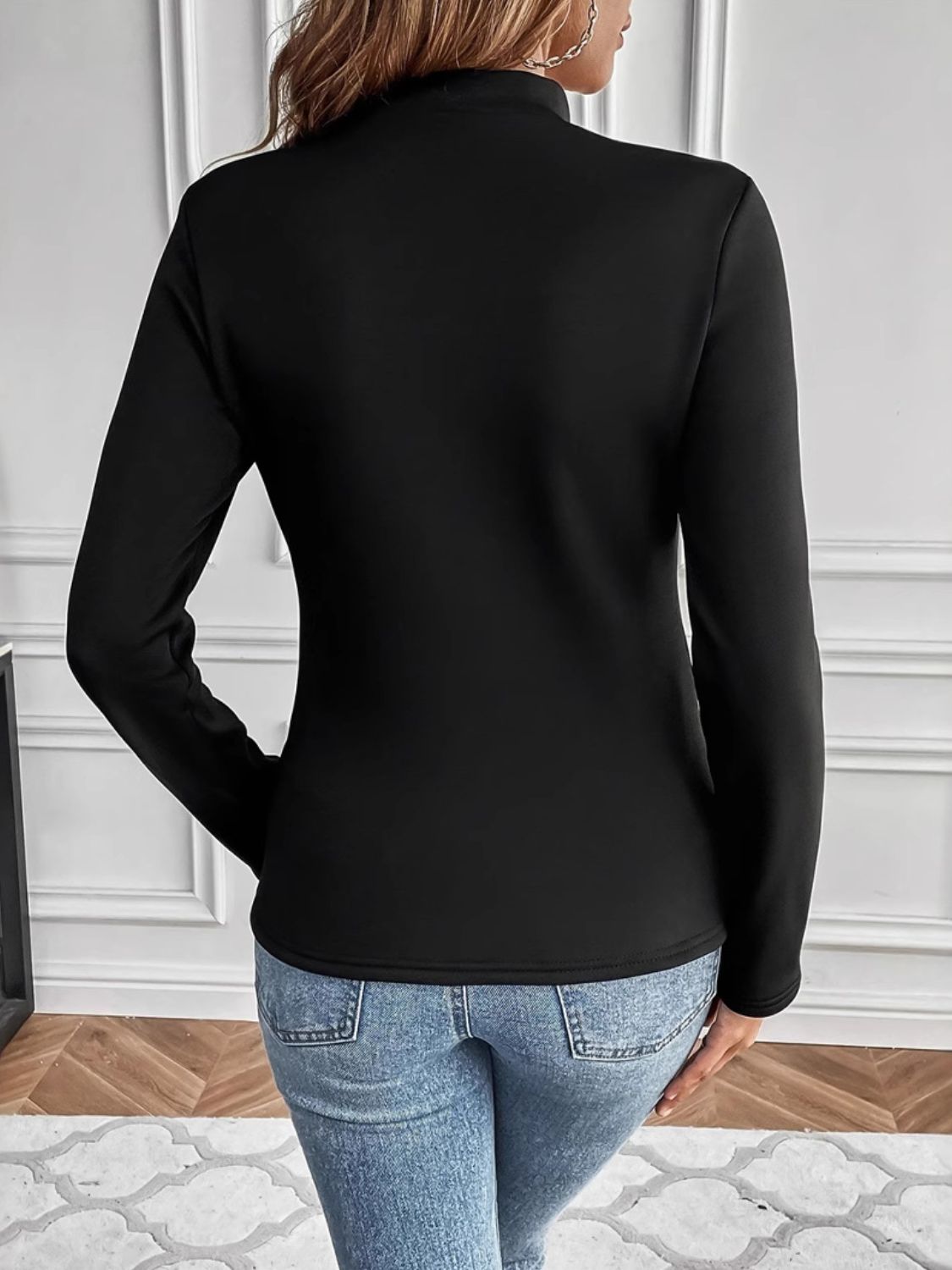 Black reversible cuff turtleneck top with long sleeves.