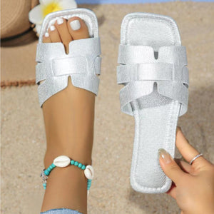 Silver woven strap flat sandals with chic cut-out design and square toe.