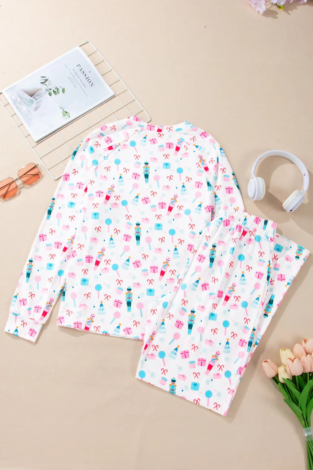 White pajama set with festive nutcracker, candy cane, and gift print.