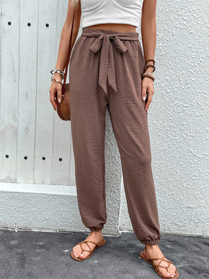 Brown textured tie-waist jogger trousers with cinched ankles