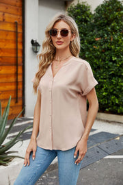 Tan cuffed sleeve v-neck blouse with button front and rolled sleeves.