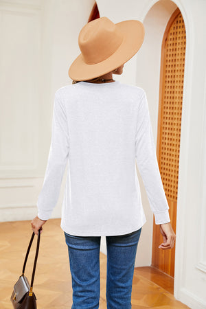 Henley-inspired long sleeve top in white with a relaxed fit, styled with jeans and a hat.