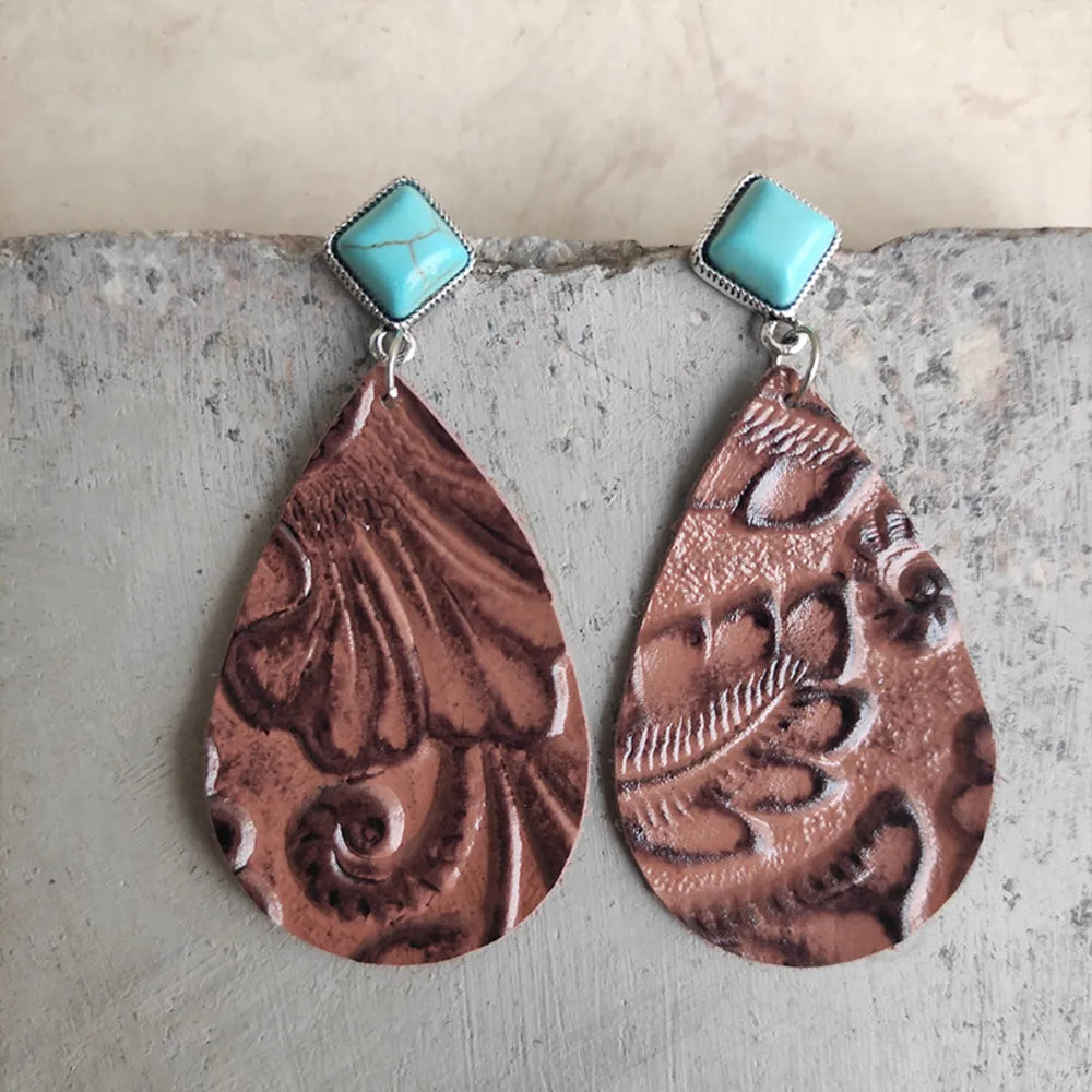Textured leather teardrop earrings with turquoise square tops in caramel color.