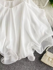 White ruffled camisole with spaghetti straps and delicate sheer layers.