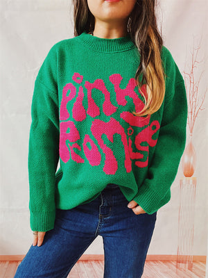 Green knit jumper with pink "Pinky Promise" graphic, crew neck, long sleeves.