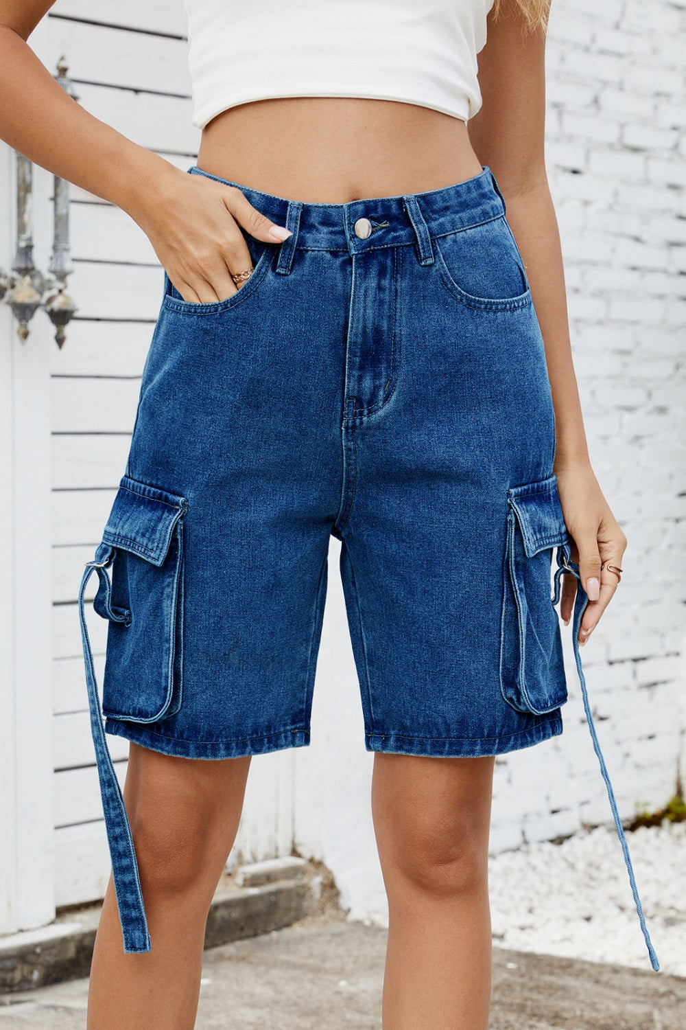 Medium blue denim cargo shorts with adjustable straps and utility pockets.