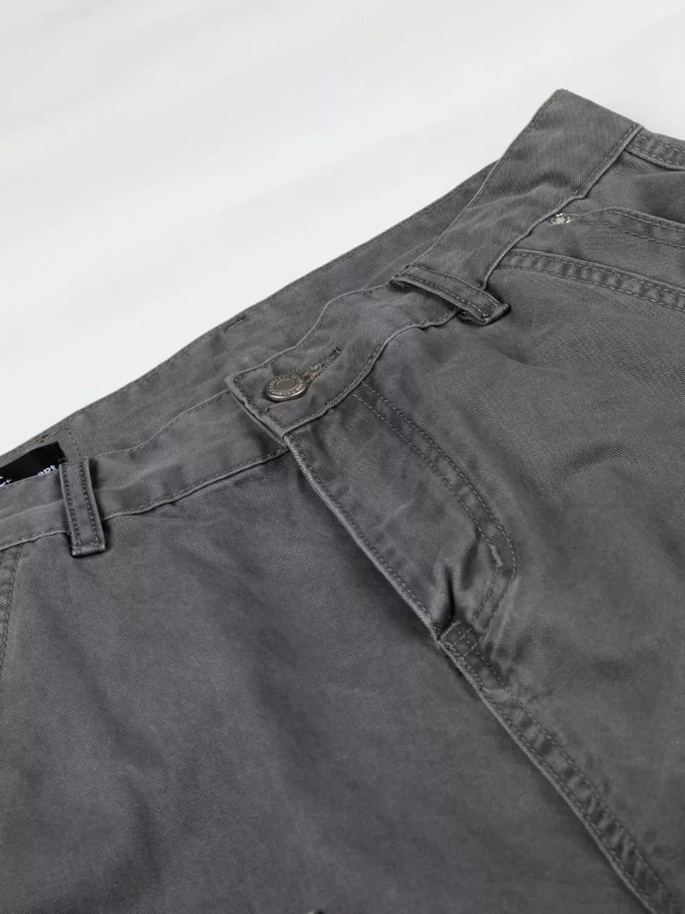 Relaxed fit grey cotton cargo capris with button closure and visible stitching details.