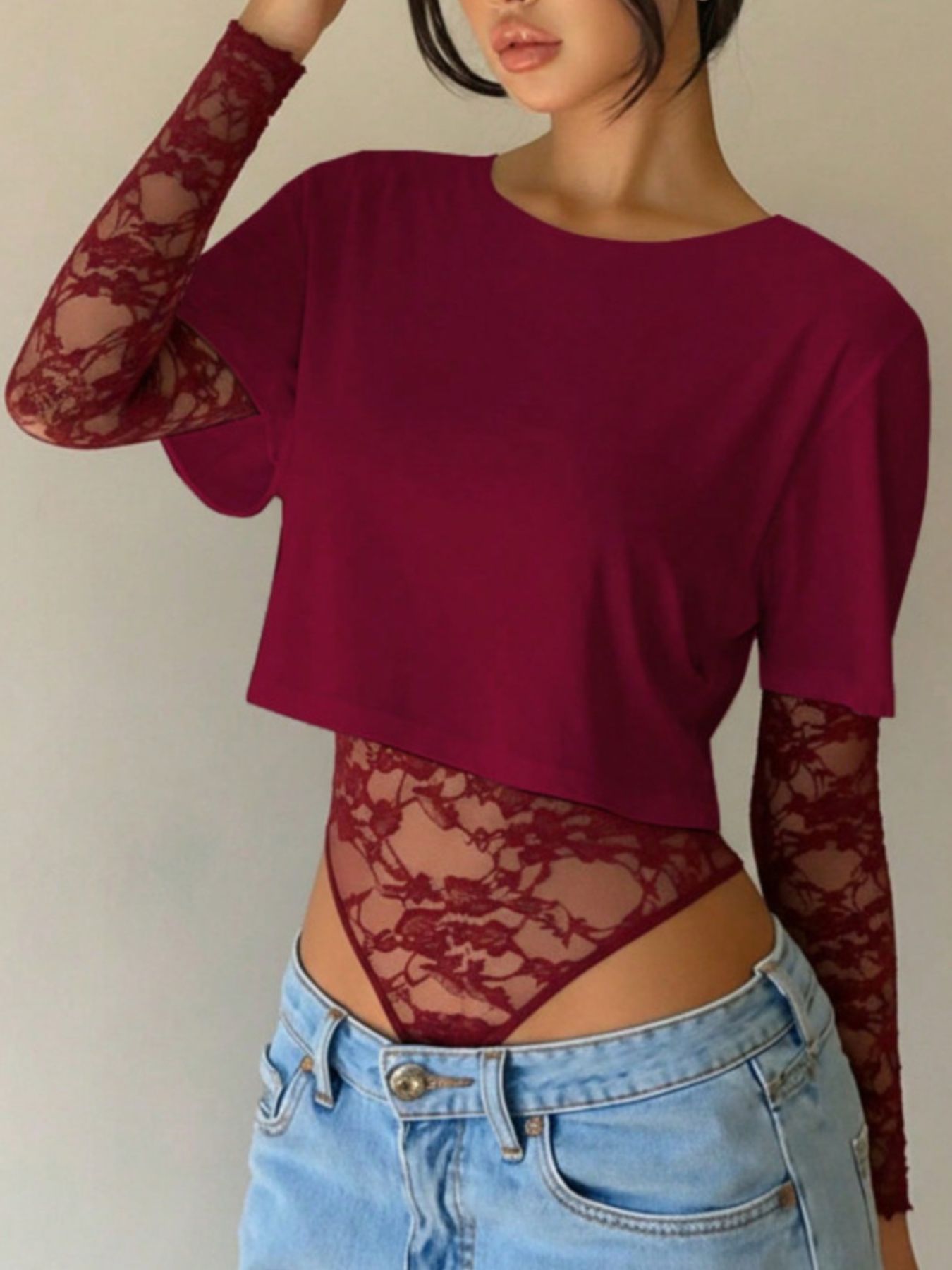 Wine red lace bodysuit with sheer long sleeves and patchwork detail.