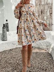 Charming beige floral tiered mini dress with long sleeves and a-line cut.