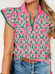 Abstract heart print polo blouse with pink collar and green trim, short flutter sleeves.