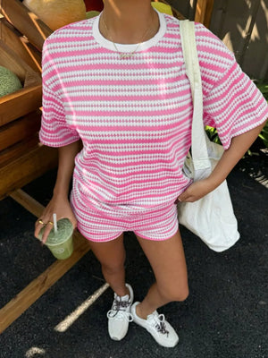 Pink striped relaxed fit two-piece set with short sleeves and shorts.