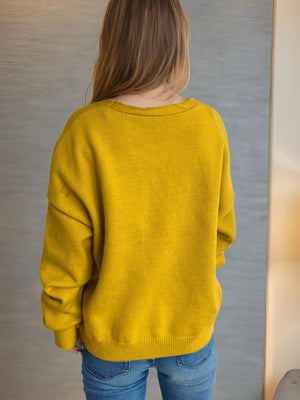 Mustard yellow acrylic oversized knit cardigan with crew neck and long sleeves.