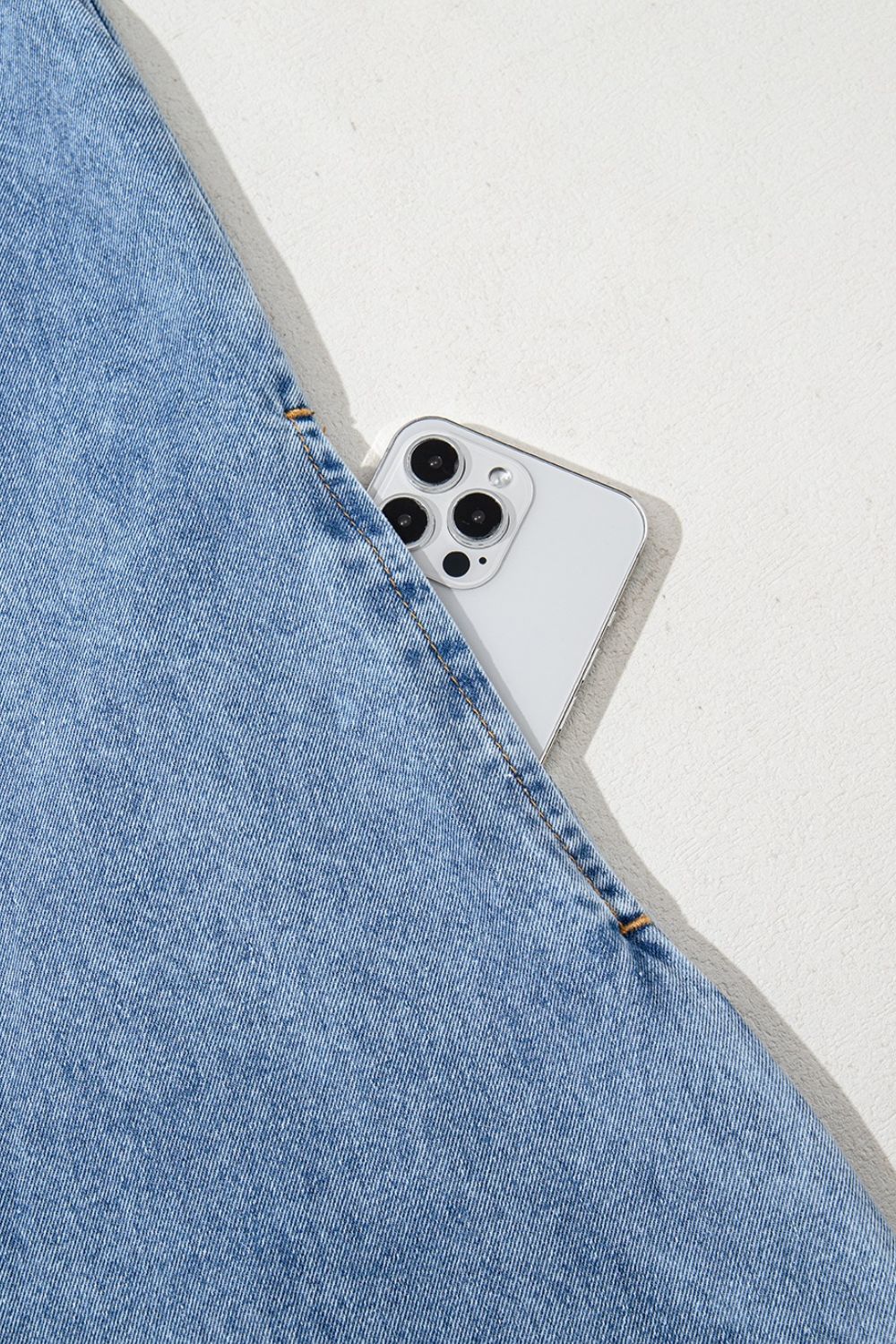 Light blue denim mini dress with a phone in the pocket