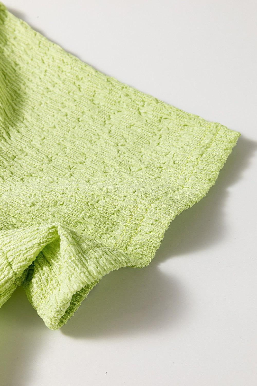 Lime textured romper with a collared neckline and patch pocket detail.