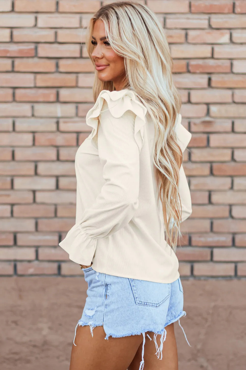 Textured ruffle sleeve blouse in eggshell with cinched cuffs.