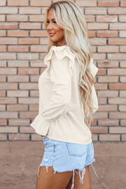 Textured ruffle sleeve blouse in eggshell with cinched cuffs.