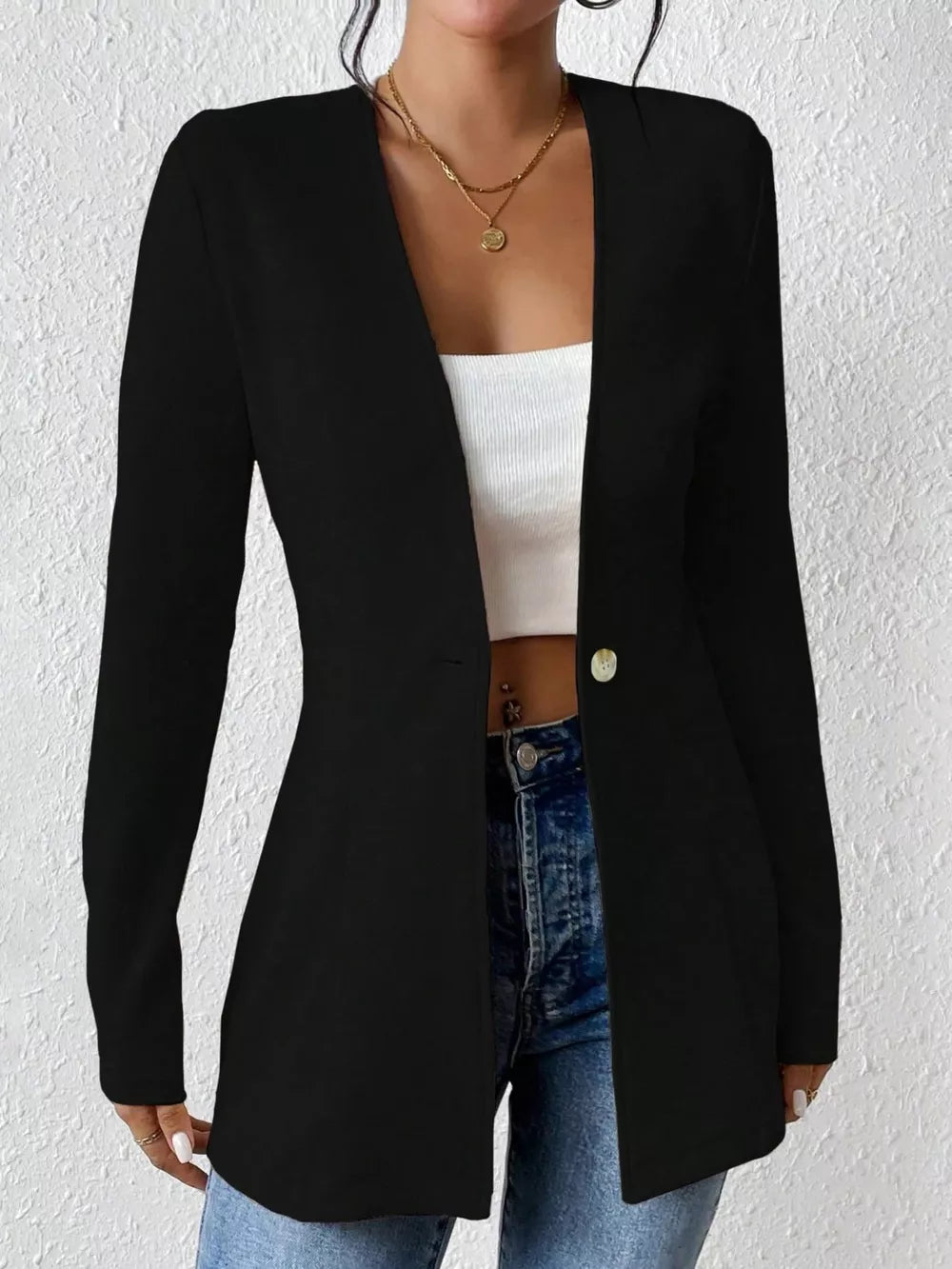 Black single-button blazer with a tailored fit and open front, styled with a white top and jeans.