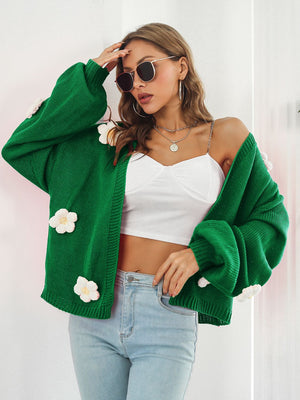 Green knit cardigan with floral appliqués and balloon sleeves.