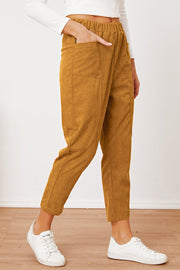 Mustard corduroy barrel-leg utility pants with elastic waist and patch pockets.