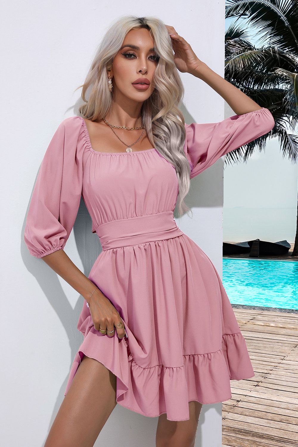 Blush pink mini dress with square neck, puff sleeves, belted waist, and ruffled hem.