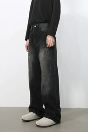 Faded wash dark wide leg denim jeans with distressed details.