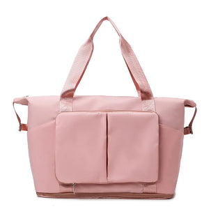 Dusty Pink foldable travel tote bag with exterior pockets and shoulder straps.