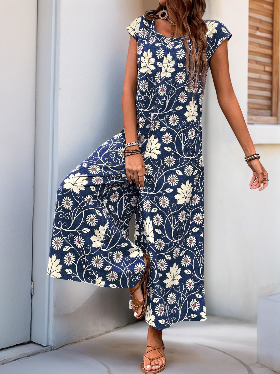 Navy botanical print culotte jumpsuit with cap sleeves and a scoop neck.