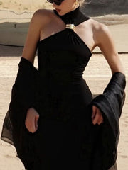 Black asymmetrical halter neck tank top with gold ring detail and flowing sleeves.