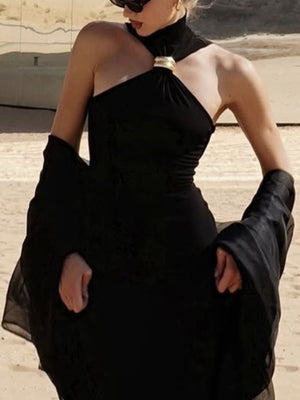 Black asymmetrical halter neck tank top with gold ring detail and flowing sleeves.