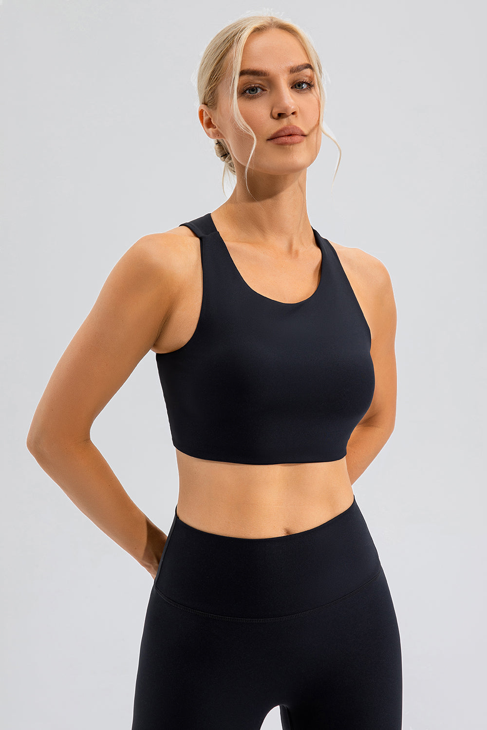 Black sports bra with asymmetric cutout detail and racerback straps