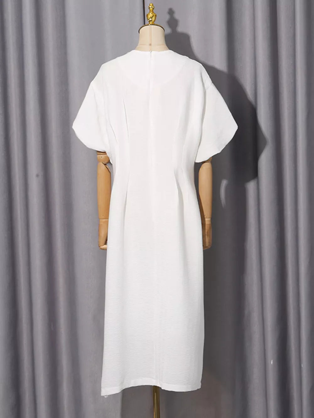 White midi dress with puff sleeves and a-line cut, featuring subtle texture.