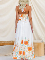 White floral halter neck maxi dress with lace-up back and border print.