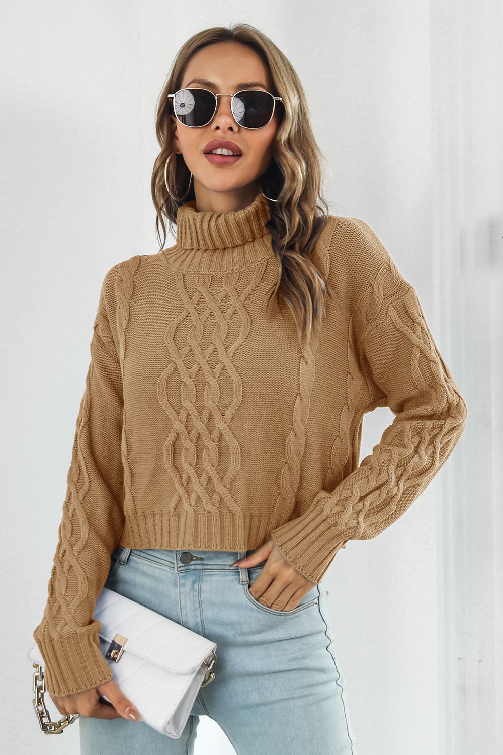 Camel cable knit cropped turtleneck sweater with braided detail and ribbed cuffs.