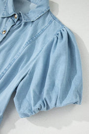 Light wash denim midi dress with a collared neckline, button front, and voluminous puff sleeves.