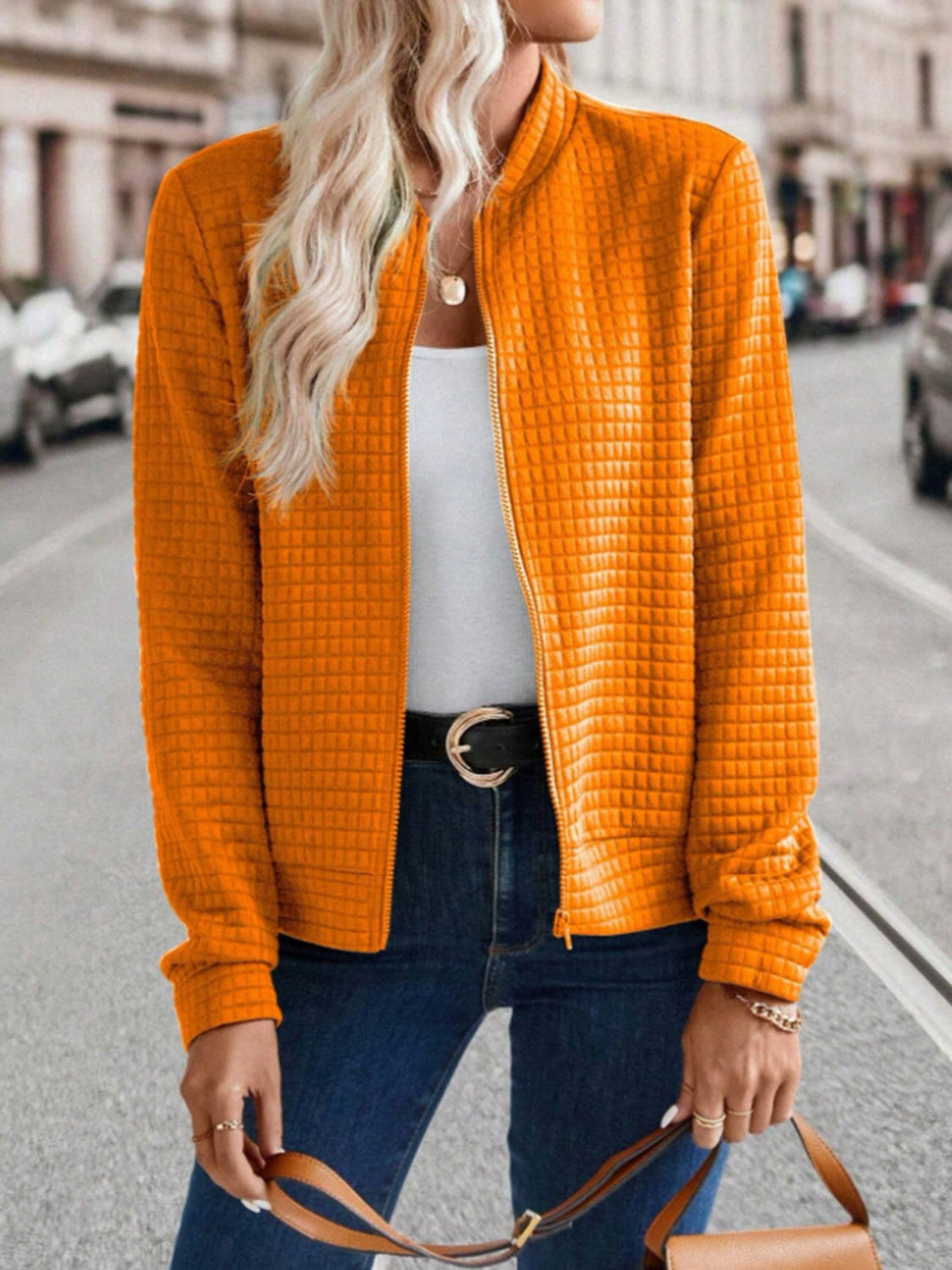 Quilted bomber jacket in Tangerine with zip closure and textured pattern.
