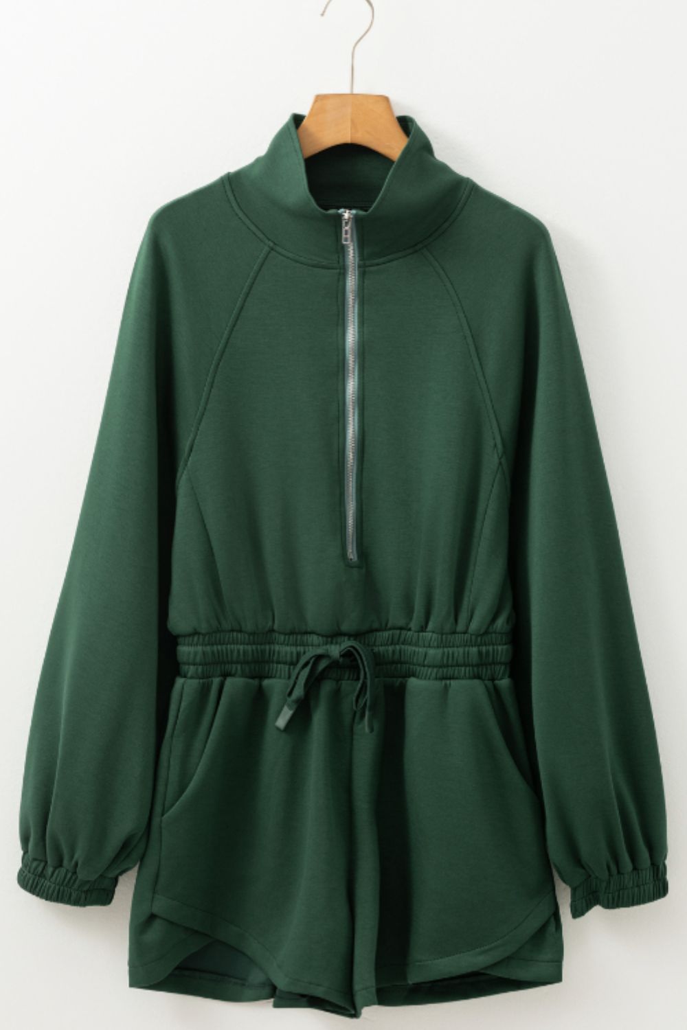 Dark green drawstring waist romper with funnel neck and quarter zip
