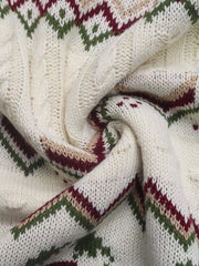 Ivory cable-knit turtleneck sweater with geometric pattern and cable knit details.