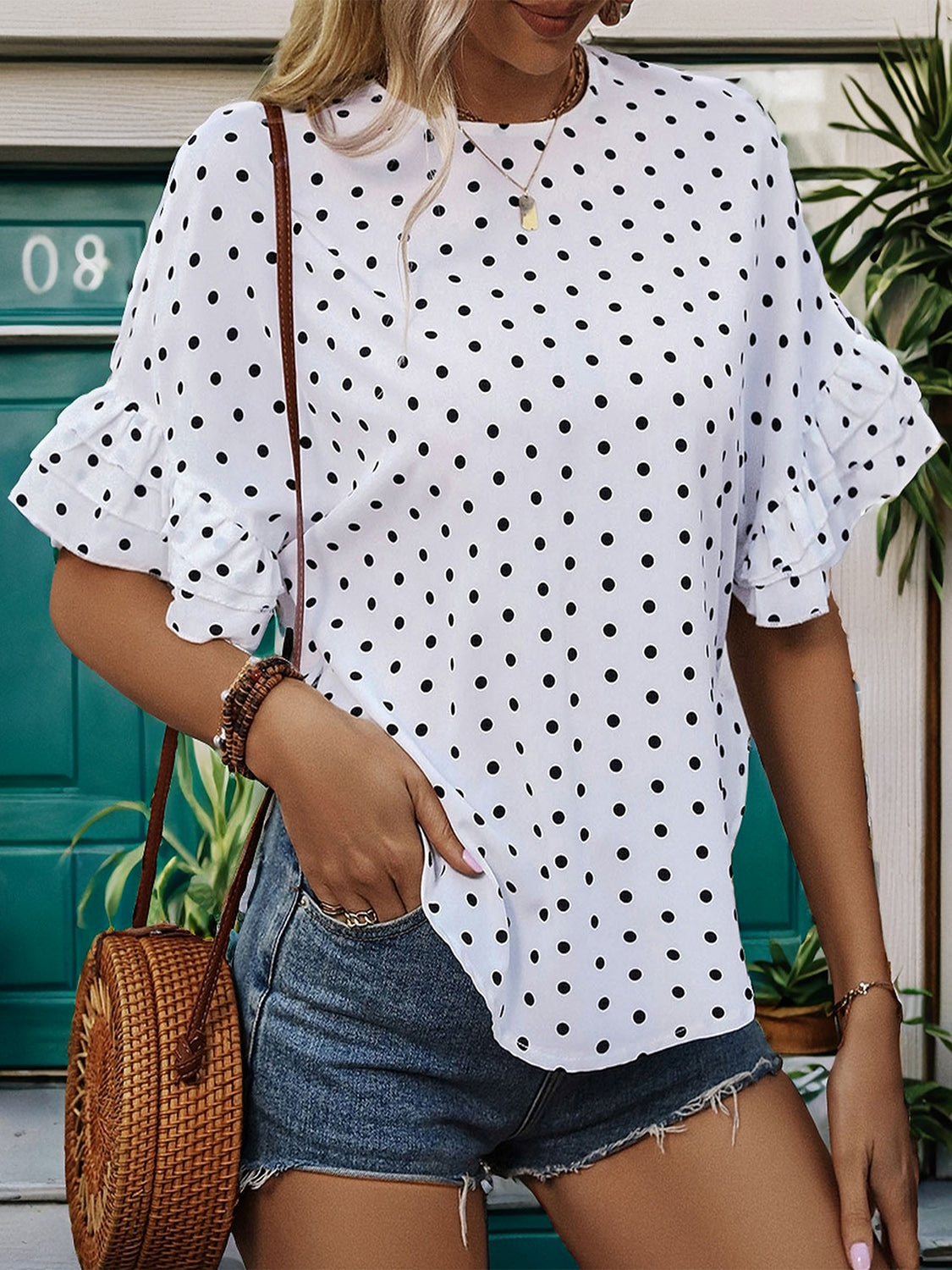 White polka dot blouse with ruffled sleeves and a keyhole neckline.