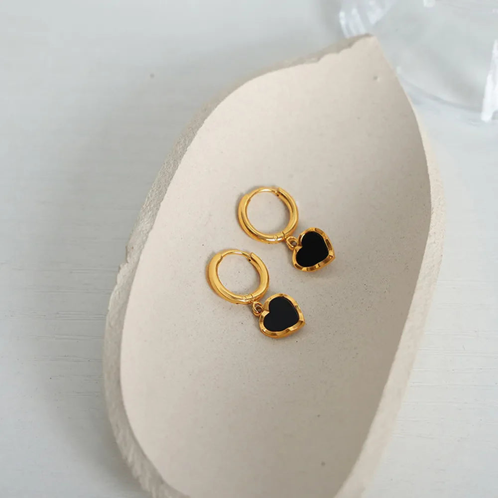 Gold hoop earrings with black enamel heart charms