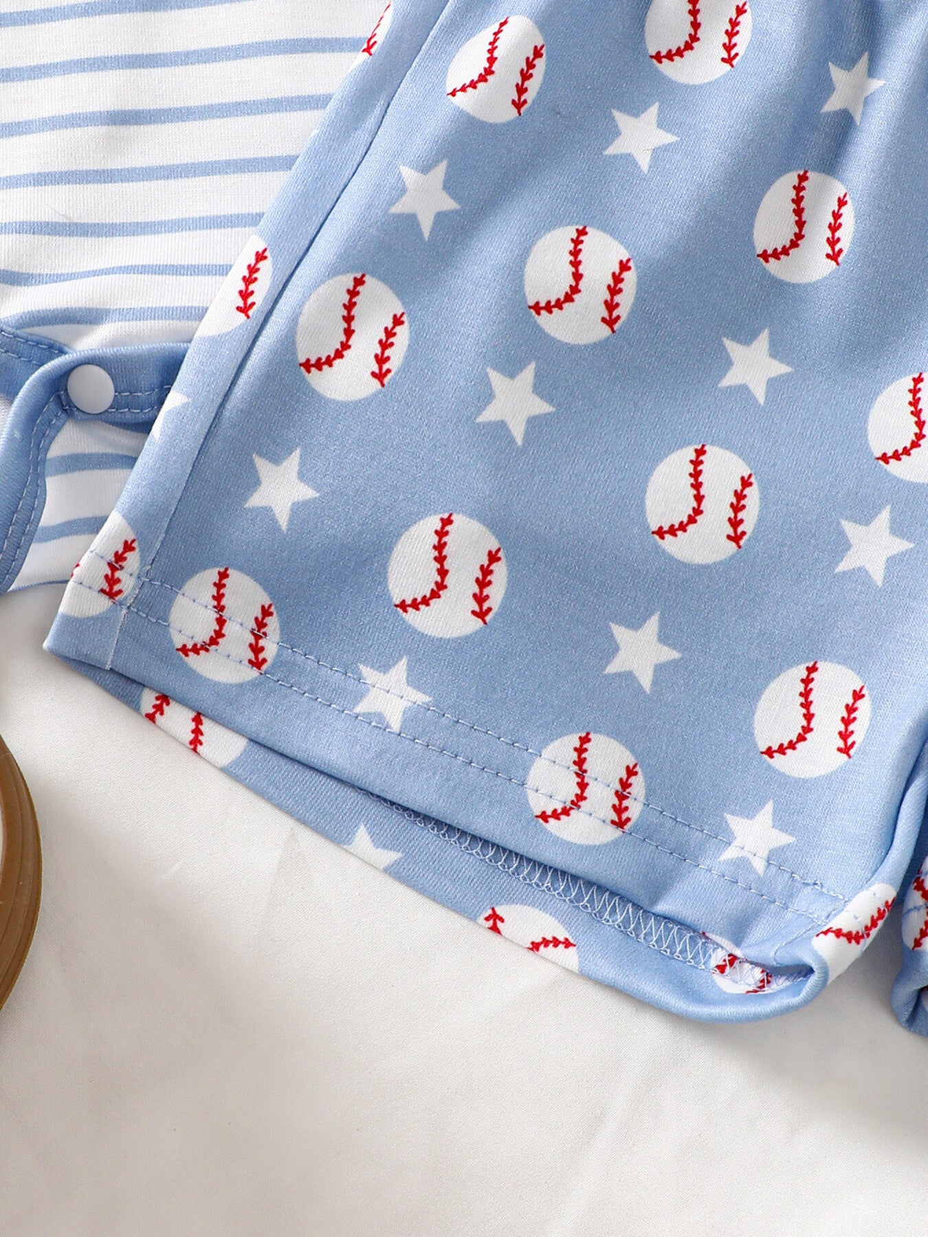 Baby bodysuit set with blue baseball and star print shorts and striped top.