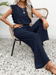 Dark blue textured jumpsuit with ruffle lace sleeves and drawstring waist.