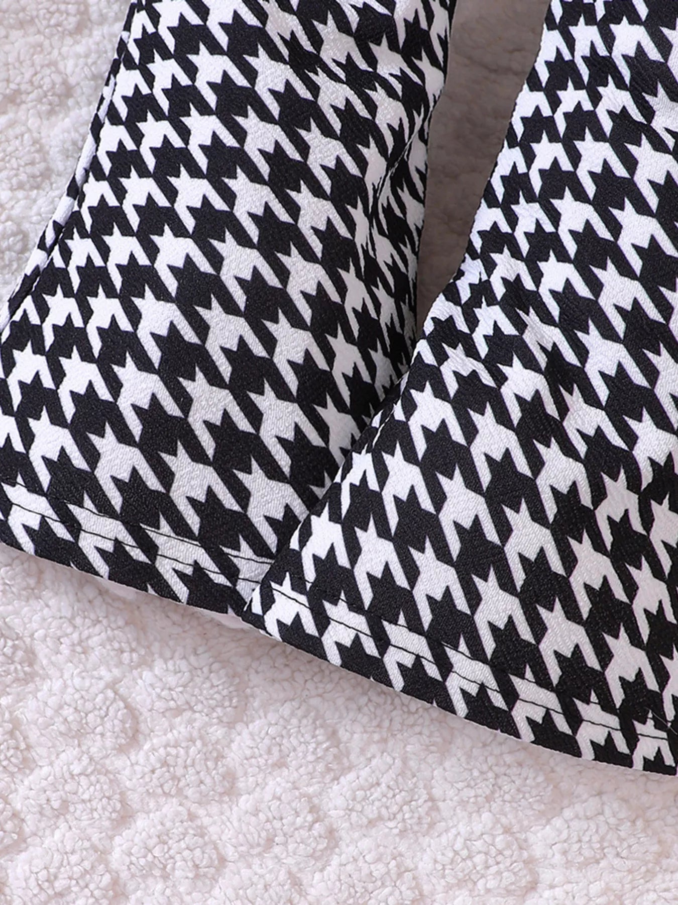 Baby houndstooth pants in black and white, close-up detail.