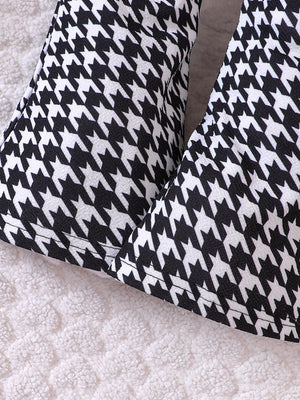 Baby houndstooth pants in black and white, close-up detail.