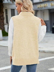 Tan cable knit sweater vest with ribbed trim and mock neck, styled over a white shirt.