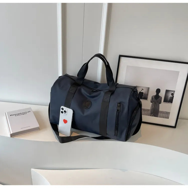 Dark Navy duffel bag with contrast straps, side zip pockets, and top handles.