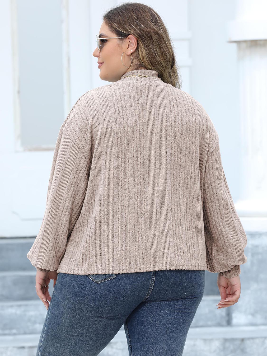 Beige ribbed knit sweater with mock neck and balloon sleeves.